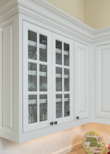 White mullion frame doors inset into upper cabinet row with glass inserts.