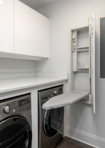 Palafox White Laundry Room Cabinets with slab doors that are push-to-open and hidden ironing board