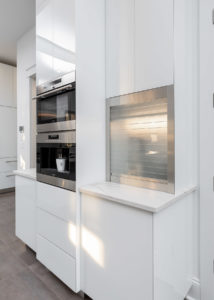Glass Tambour Door rolled down on white coffee bar cabinet