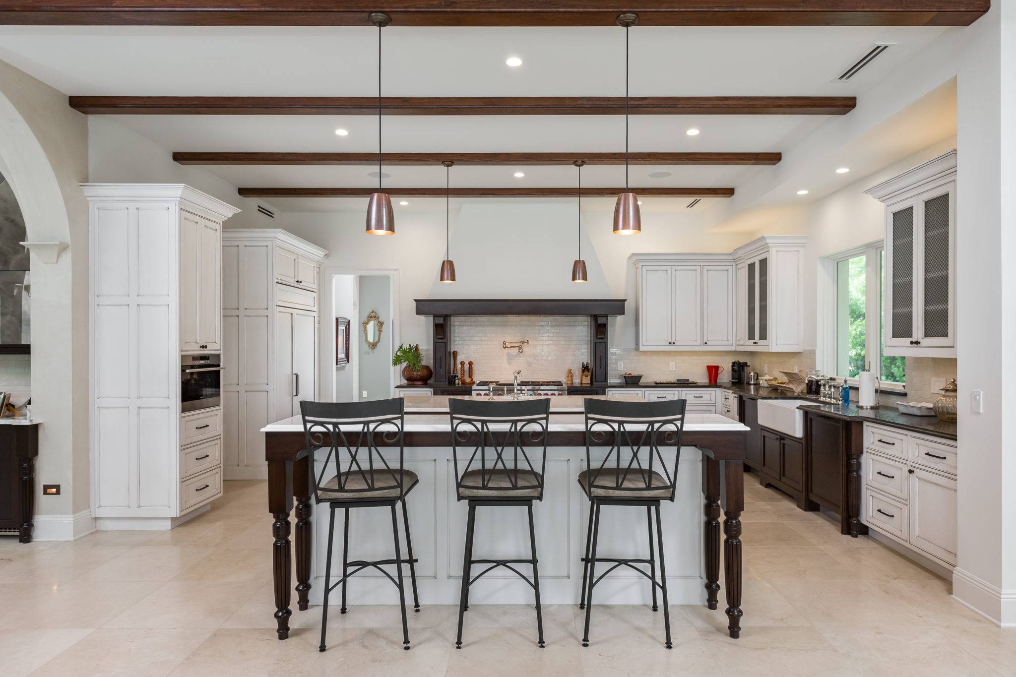 Tuscan Styled Kitchen with beaded inset cabinetry and recessed panel doors decorated with top knobs hardware