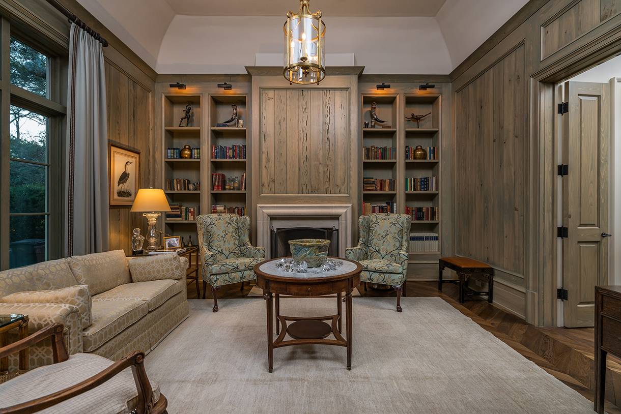 Custom library built completely out of pecky cypress wood featuring a secret bookshelf door